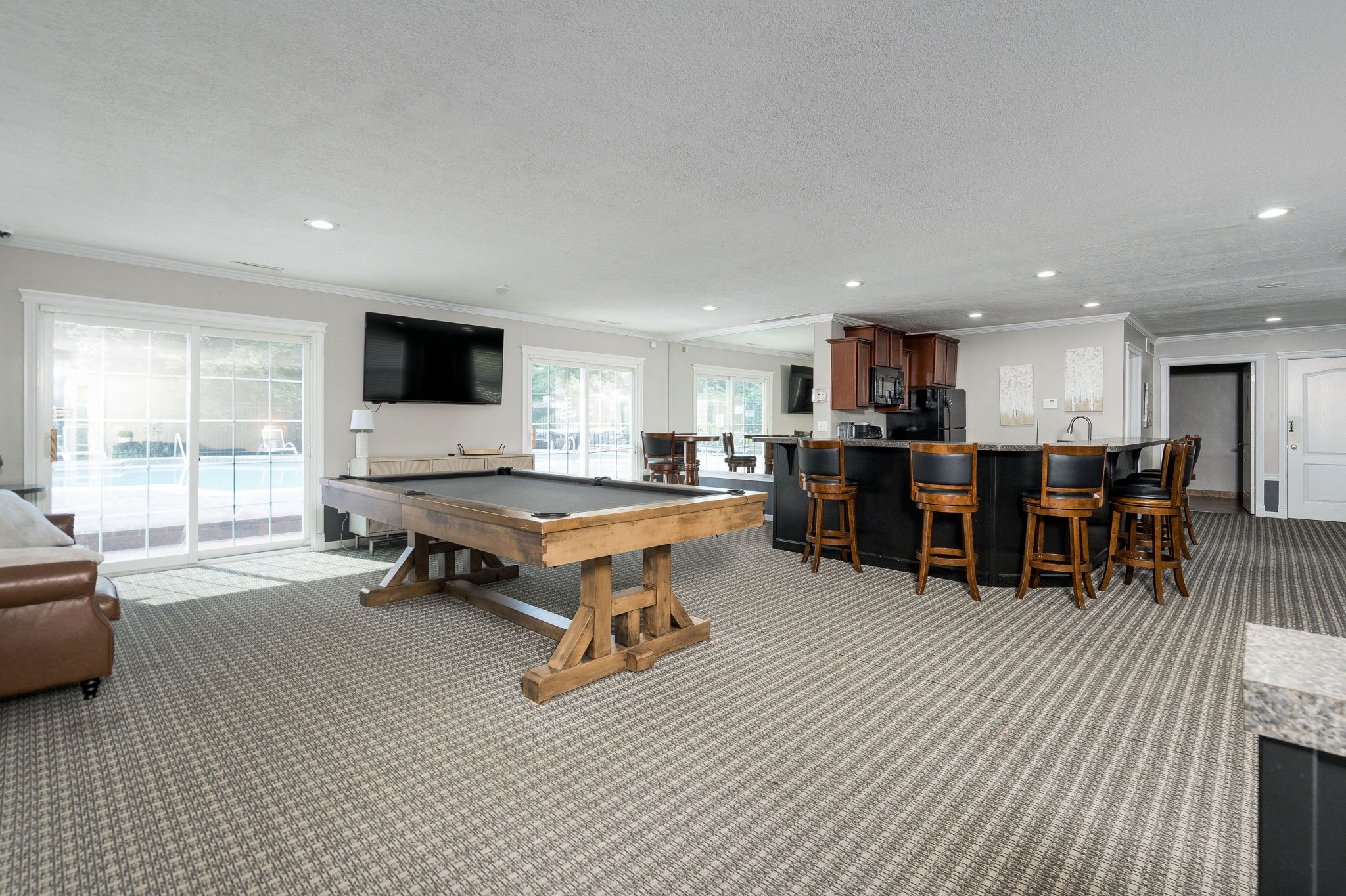 A large room with a pool table and a television.